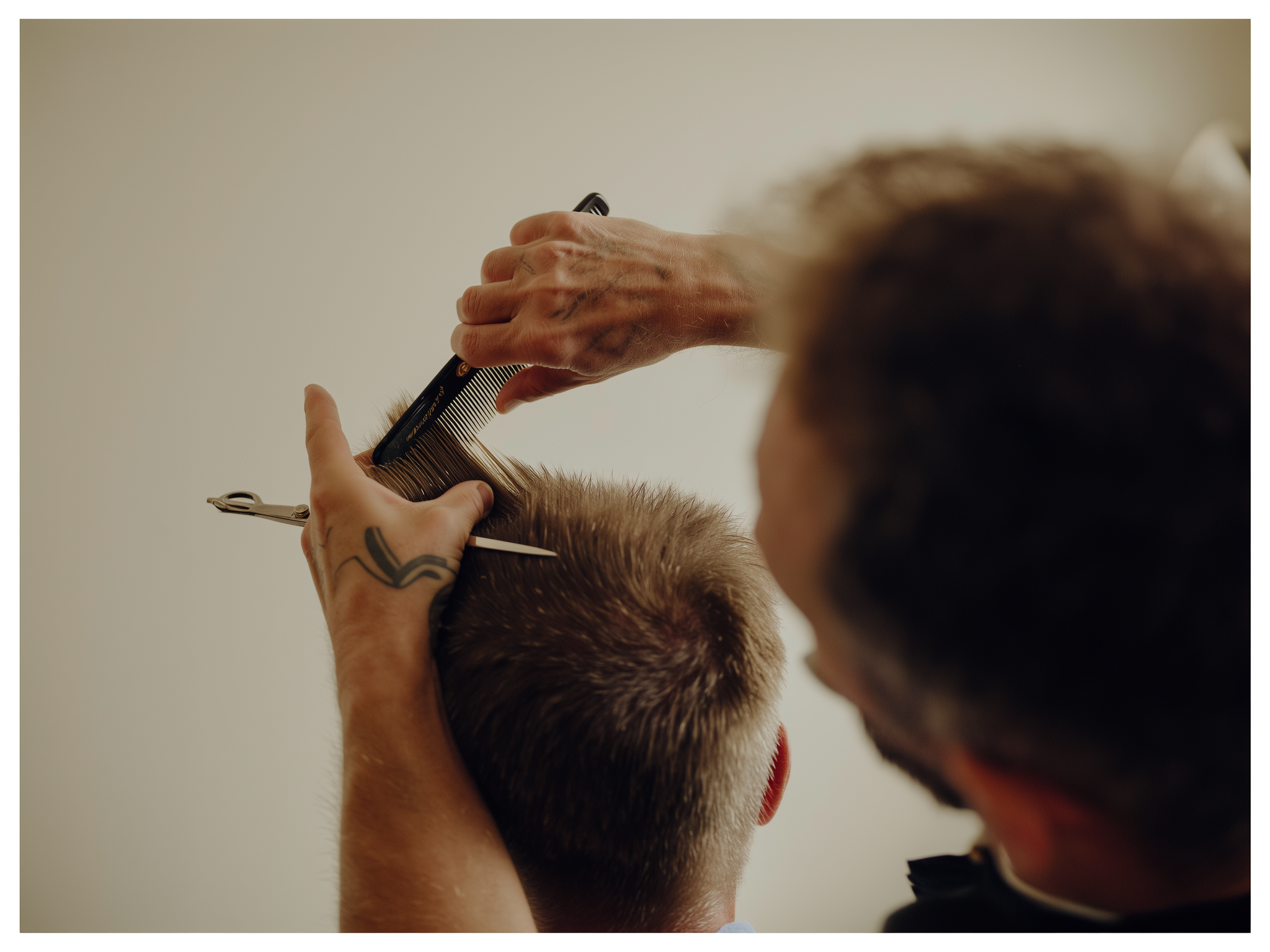 Een kapper knipt met kam en schaar de haren in model.